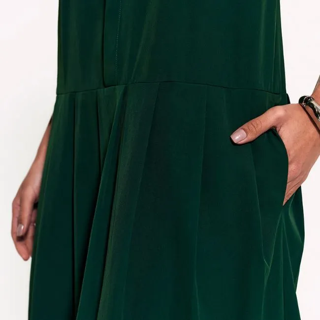 Detalhe de vestido verde escuro com bolso lateral e caimento fluido, ideal para look sofisticado e moderno feminino.
