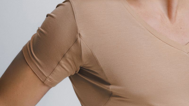 Camiseta bege sem manchas de suor nas axilas, evidenciando eficácia da undershirt Insider.
