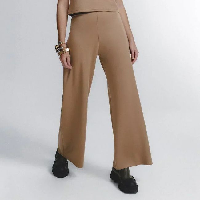 Calça wide leg feminina em tom bege, tendência de moda para meia-estação, combinando estilo moderno, caimento fluido e conforto térmico.