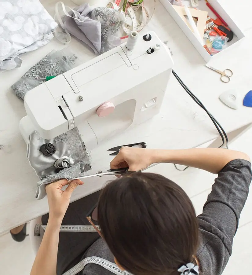 estilista costurando roupas com a ajuda de uma máquina de costura
