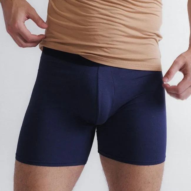 Look masculino com camiseta básica bege e cueca boxer azul ajustada, roupa confortável e minimalista para o dia a dia.